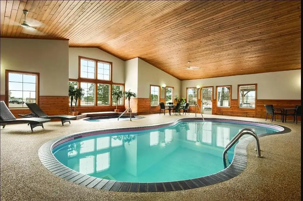 The indoor pool and hot tub under a pitched cedar ceiling